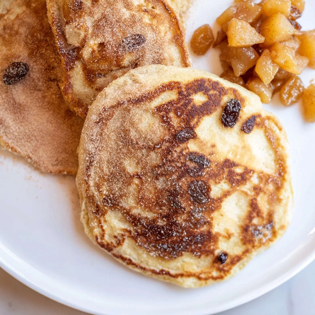 Warm, golden Quarkkeulchen pancakes served with sweet, tangy apple compote, perfect for breakfast.