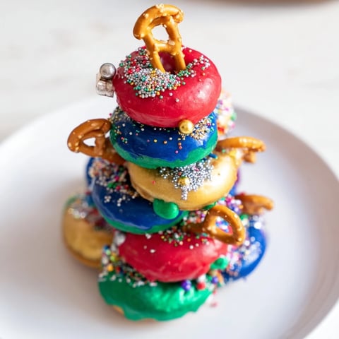 A delicious donut stack Christmas ornament tower, an edible dessert centerpiece sparkling with festive sprinkles.