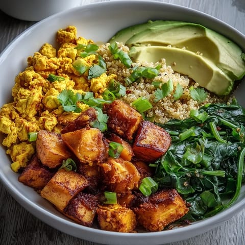 Bunte Vegan Breakfast Bowl mit würzigem Tofu-Rührei und Avocadosalat.