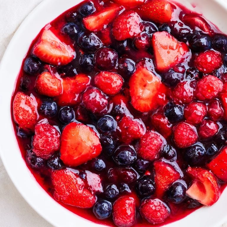 Leckerer Beerencoupage aus frischen Erdbeeren, Himbeeren und Blaubeeren, perfekt für Joghurt.