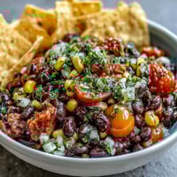 Lebendiger Cowboy-Caviar-Dip mit schwarzen Bohnen, Mais und Pico de Gallo, perfekt für Sommerpartys.